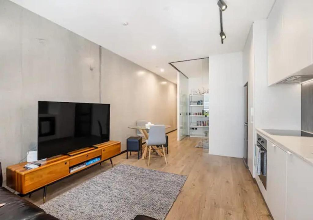 uma sala de estar com uma grande televisão de ecrã plano em Classy and contemporary living em Auckland