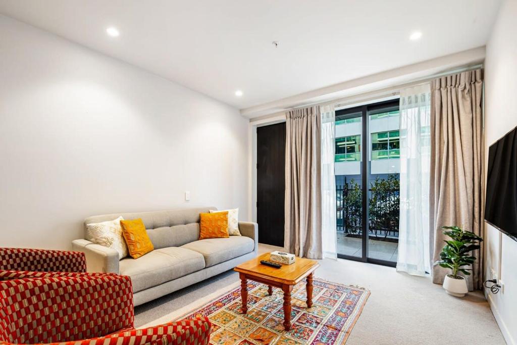 a living room with a couch and a table at Spacious Mount Eden Apartment in Auckland