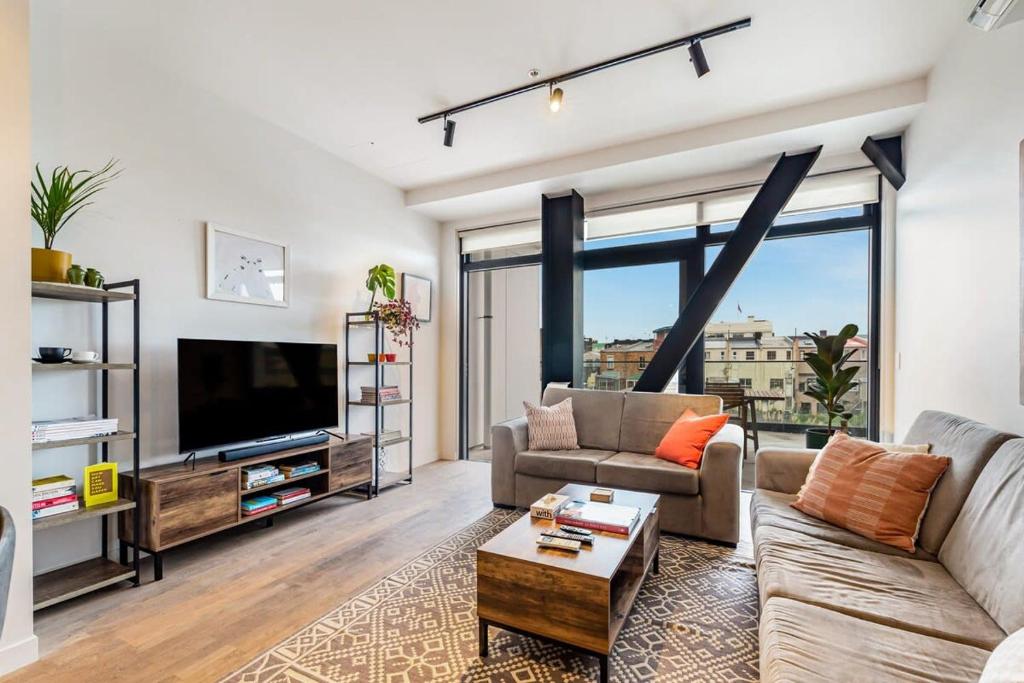 uma sala de estar com um sofá e uma televisão em Modern living in prime location em Auckland