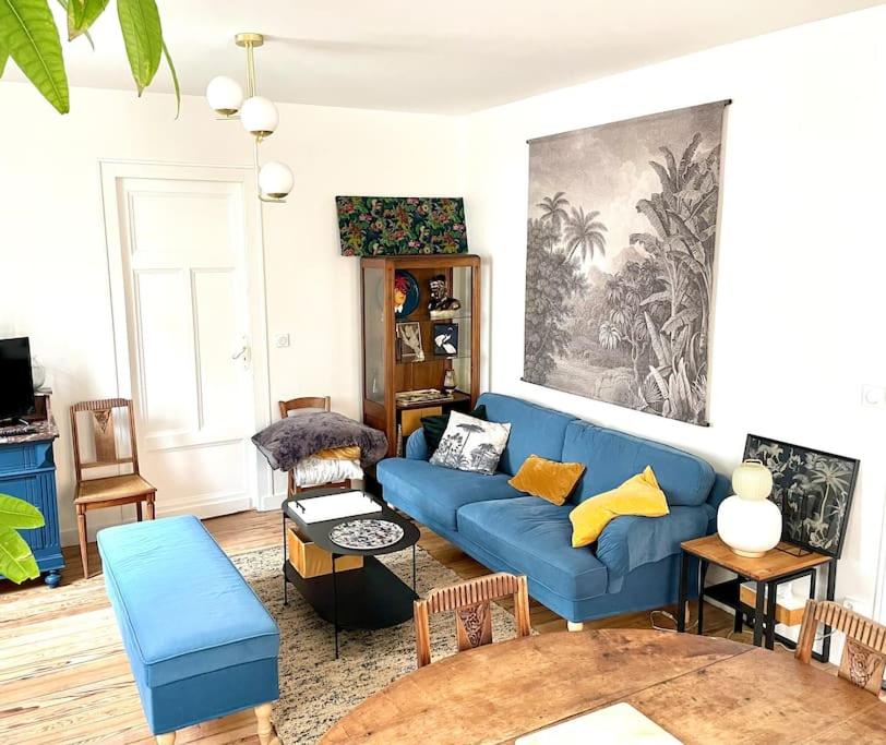 un salon avec un canapé bleu et une table dans l'établissement COCON ART DECO - ARCACHON CENTRE & PLAGE - L'Europe, à Arcachon