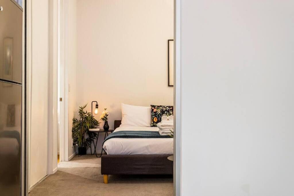 a bedroom with a bed and a table and a mirror at Cosy Queen St 1-BR apartment in Auckland