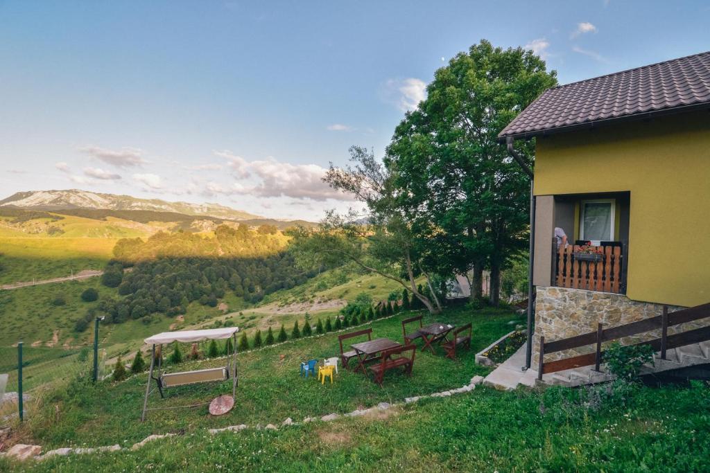 a house with a balcony with a table and benches at Relaxing holiday house in Sarajevo