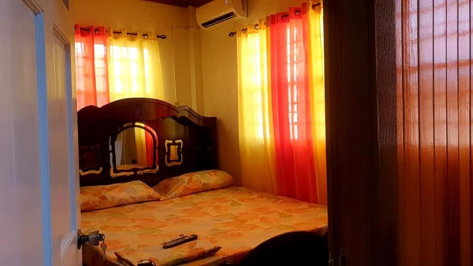 1 dormitorio con 1 cama con espejo y ventanas en S&S Guyana Real Estate Apartment, en Georgetown