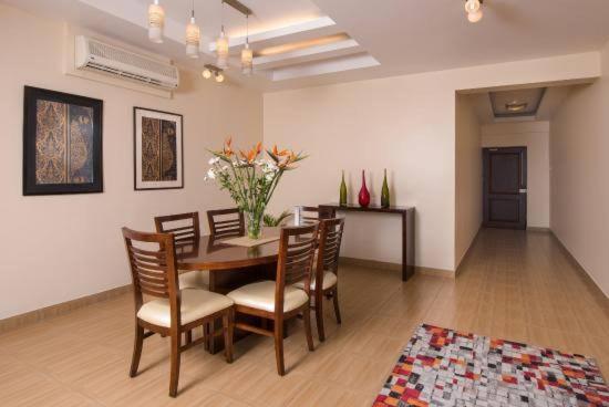 a dining room with a table with chairs and flowers at 4 Bedroom apartment at Uhuru Heights in Dar es Salaam