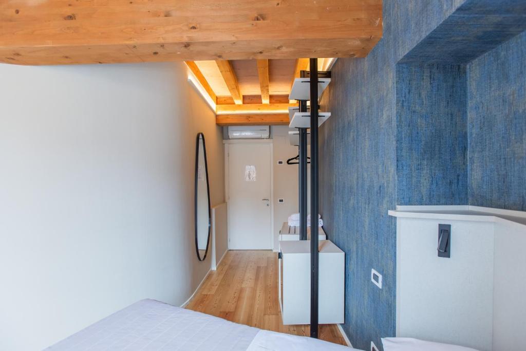 um quarto com uma cama e uma parede azul em Albergo Del Sole em Varenna