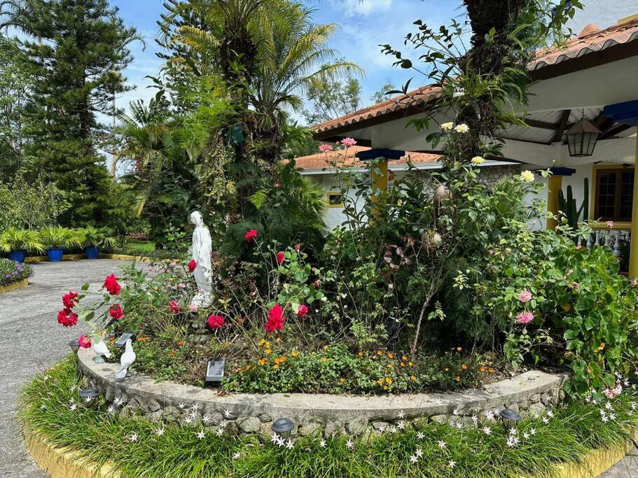 un jardín con una estatua y flores en un patio en Quinta Las Victorias en El Valle de Antón
