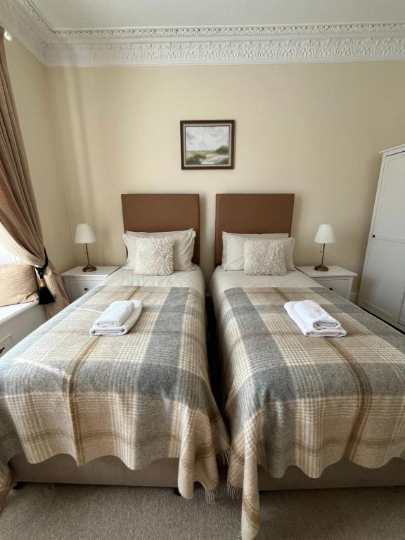 two beds sitting next to each other in a bedroom at Acorn House Callander in Callander