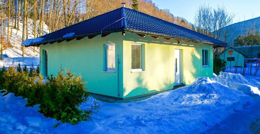 ein kleines Haus im Schnee mit Schnee drum herum in der Unterkunft Apartmán Zlatonka in Ostravice