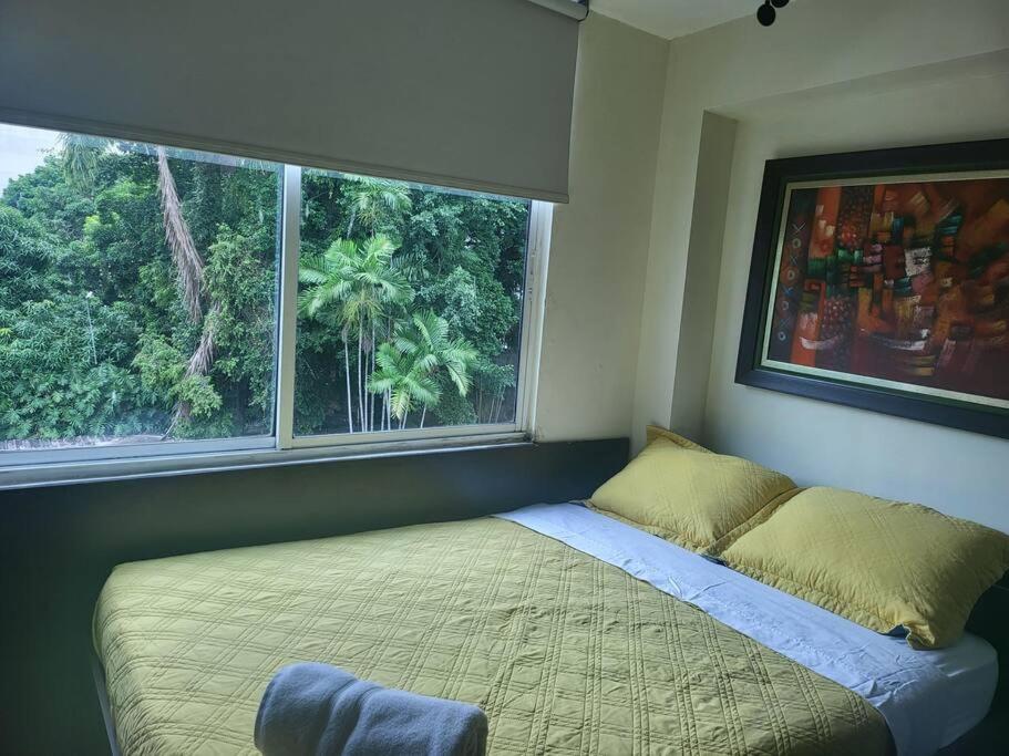 a bed in a bedroom with a large window at R.7-7 Lindo estudio de 2 recámaras, zona turística in Panama City