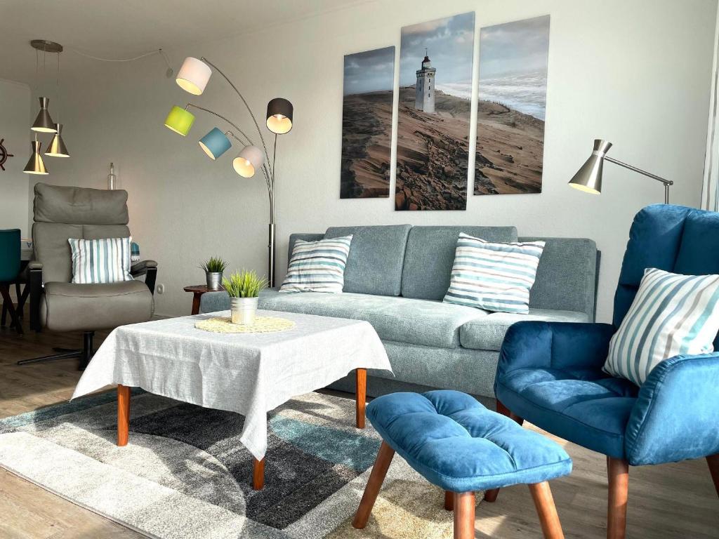 een woonkamer met een bank en een tafel en stoelen bij Frische-Brise-FeWo-15-03 in Cuxhaven