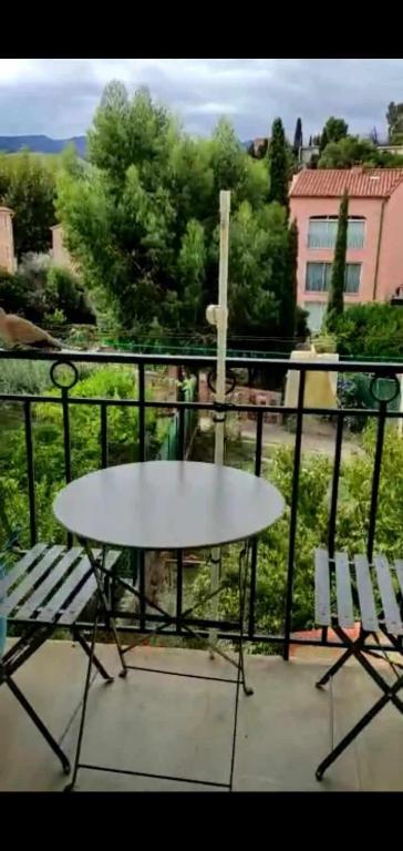d'une table blanche et de deux chaises sur un balcon. dans l'établissement Chez Nissa, à Banyuls-sur-Mer
