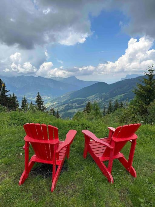 2 chaises rouges assises au sommet d'une colline dans l'établissement La Clusaz Escape, à Manigod