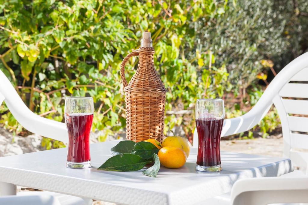 una mesa con dos vasos de zumo y fruta. en Stone House Moj Dida en Živogošće