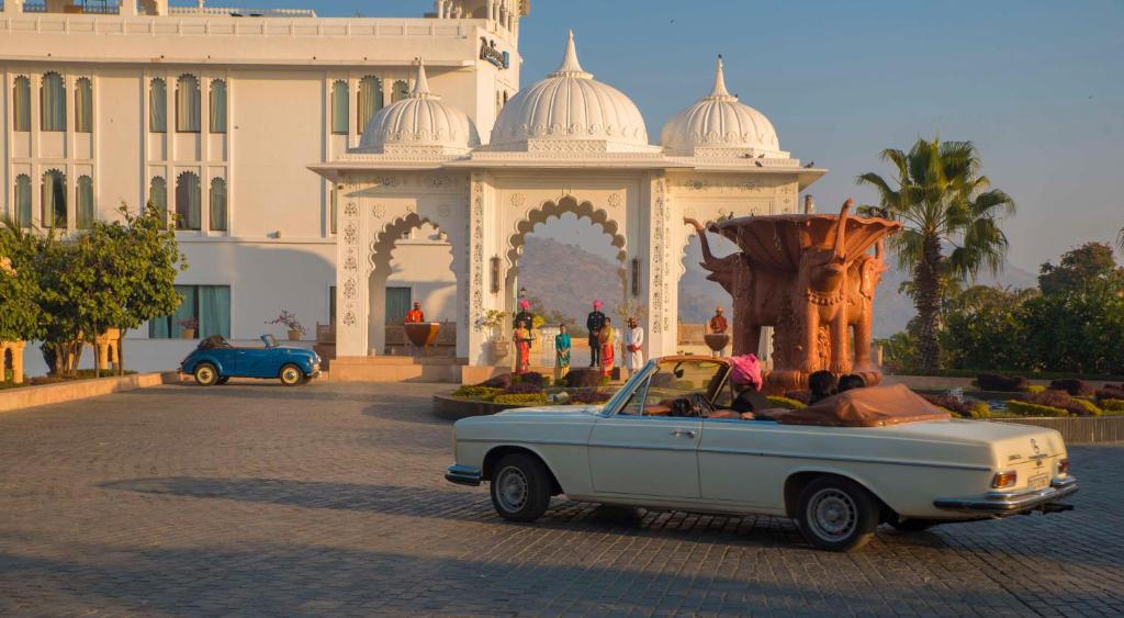 un coche viejo estacionado frente a un edificio en Radisson Blu Udaipur Palace Resort & Spa en Udaipur