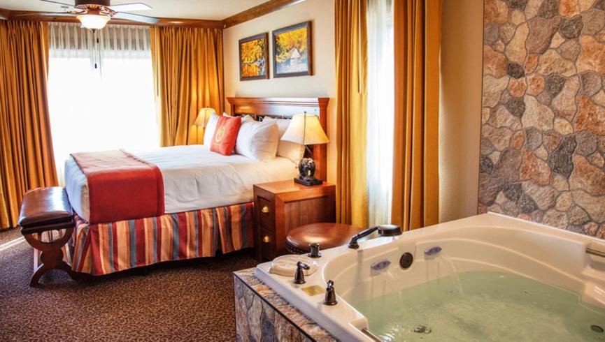 a hotel room with a bed and a bath tub at King Size bed Room with Hot tub in Gatlinburg