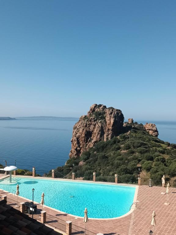 een zwembad met een berg op de achtergrond bij Il Miraggio Tanca Piras in Nebida