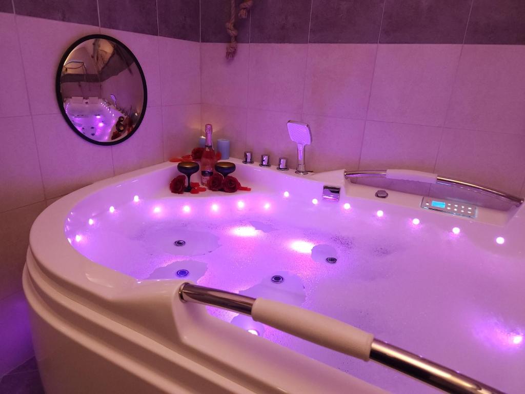 a bathroom with a tub with lights in it at JACUZZI & SAUNA Apartament Gdańsk nad morzem in Gdańsk
