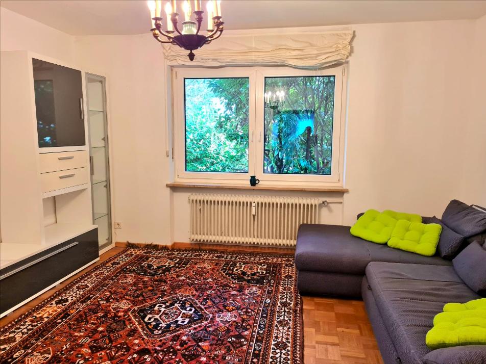 sala de estar con sofá y ventana en Garden Oasis Retreat: Apartment with Terrace, en Múnich
