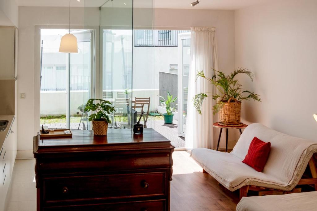 a living room with a dresser and a chair with plants at Apartment in Santos in Lisbon
