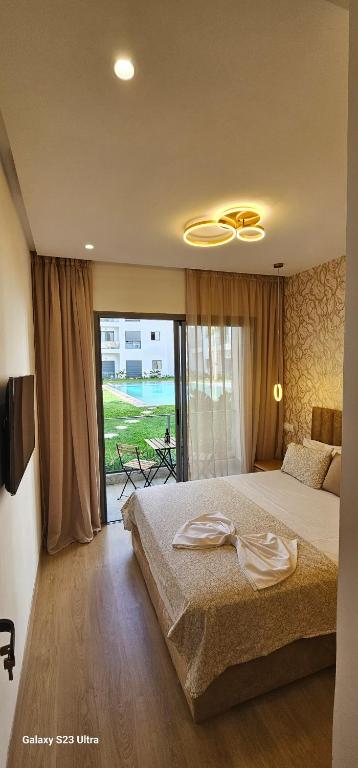 een slaapkamer met een groot bed en een groot raam bij Studio Cosy Confortable pour un Séjour Relaxant in Nouaceur