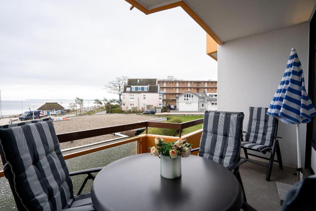 ein Tisch und Stühle auf einem Balkon mit Blick auf das Meer in der Unterkunft Berliner Hof - HOF/210 in Scharbeutz