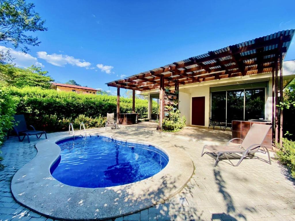 een patio met een zwembad en een huis bij Cozy dog-friendly apt w/shared pool - close to Tamarindo in Huacas