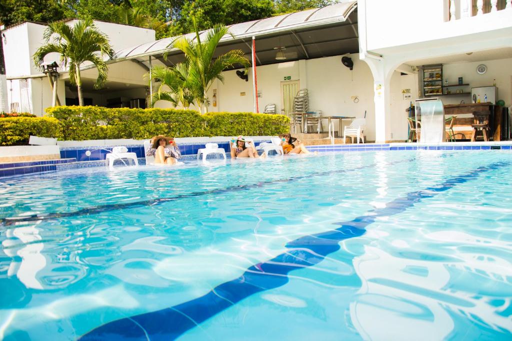 a group of people sitting in a swimming pool at Hotel villeta suite in Villeta