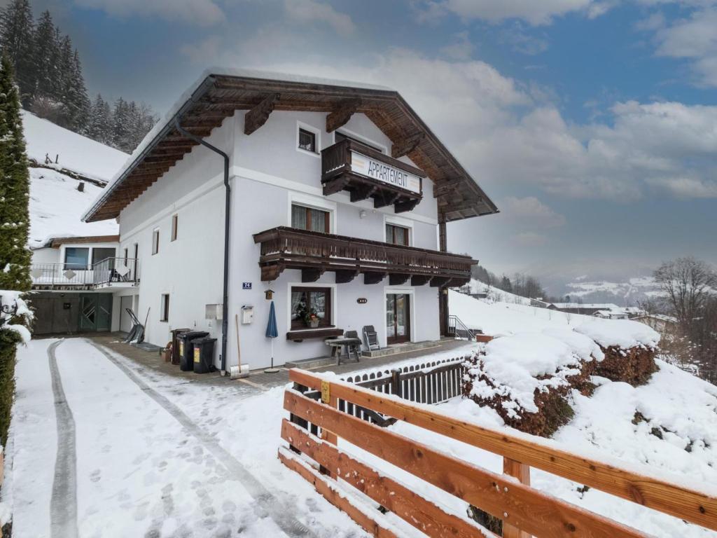 een wit huis met een houten hek in de sneeuw bij Vanessa in Zell am See