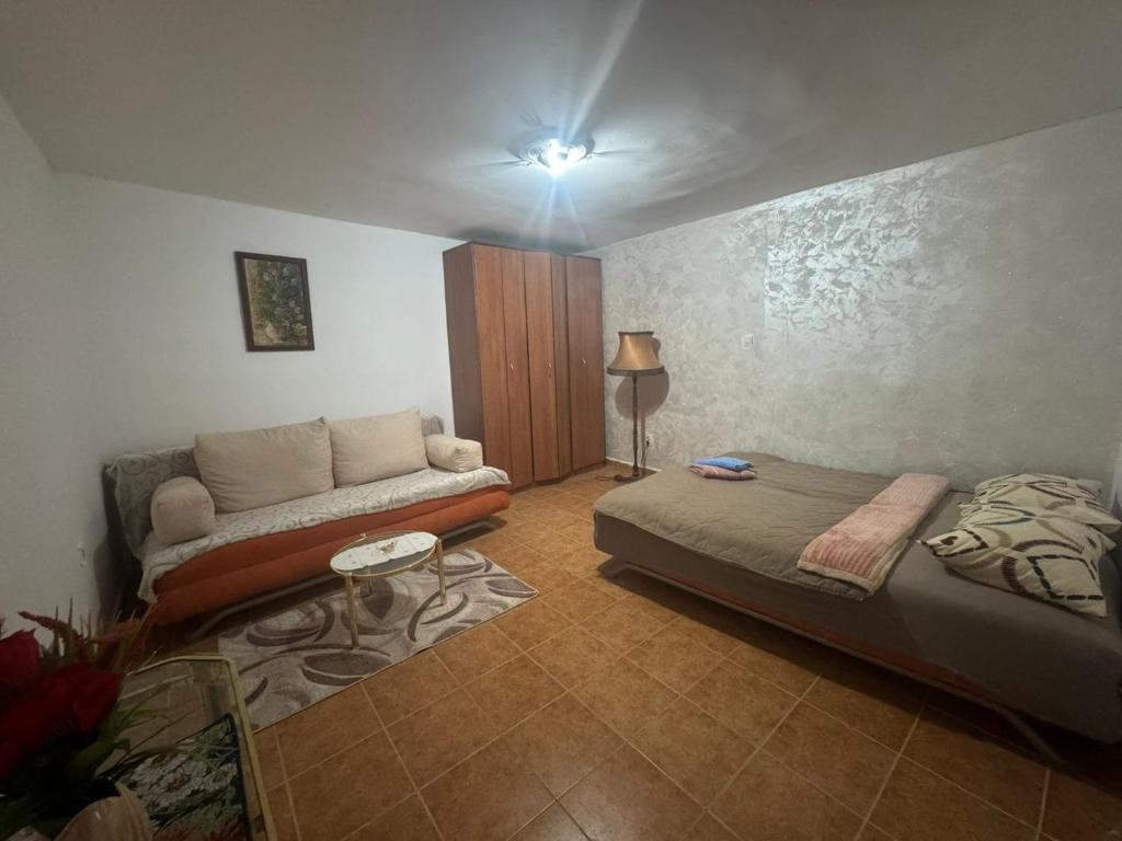 salon z łóżkiem i kanapą w obiekcie Konak w mieście Podgorica