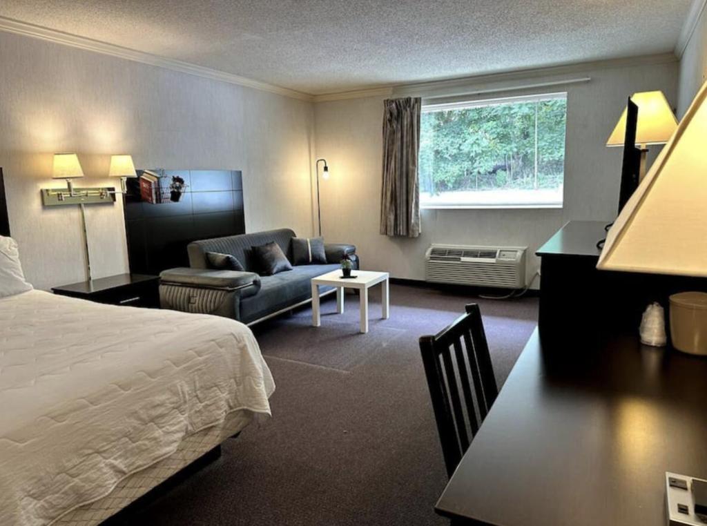 Kiteville Phoenixville في فونكسفيل: غرفة في الفندق بسرير وكرسي ومكتب