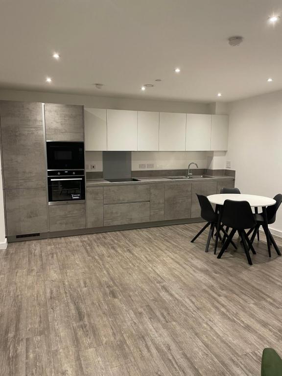 a kitchen with a table and chairs in a room at Luxurious 2 Bedroom Apartment in Barking
