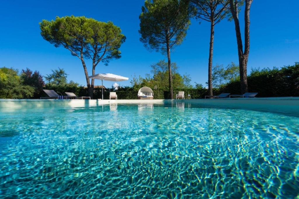 une piscine d'eau bleue et d'arbres dans l'établissement Ferienhaus für 10 Personen in Altopascio, Toskana Provinz Lucca, à Altopascio