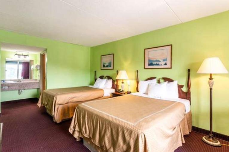 a hotel room with two beds and green walls at FairBridge Inn Express Mount Vernon Renfro Valley in Mount Vernon