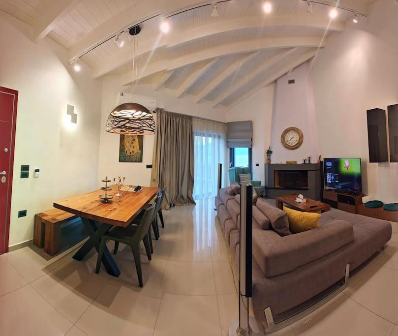 een grote woonkamer met een tafel en een bank bij Alexiou Luxury Villa in Aigio