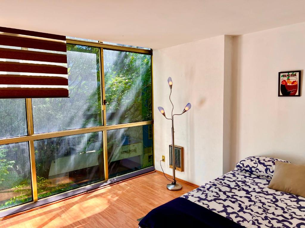 a bedroom with a large window and a bed at Casa Camara in Mexico City