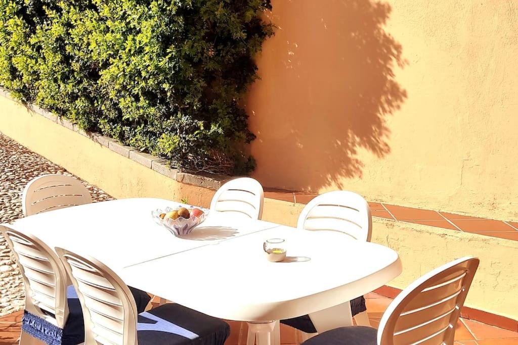 two white tables and chairs on a patio at Ampio appartamento mare in Putzu Idu