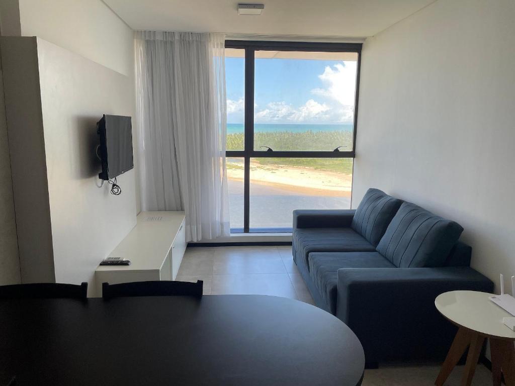 - un salon avec un canapé bleu et une table dans l'établissement Hosts BR - Frente Mar c/ cozinha, à Récife
