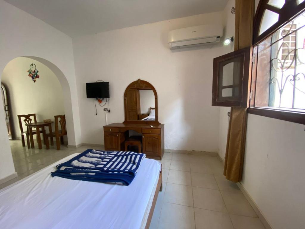 een slaapkamer met een bed, een bureau en een raam bij Red oasis in Dahab
