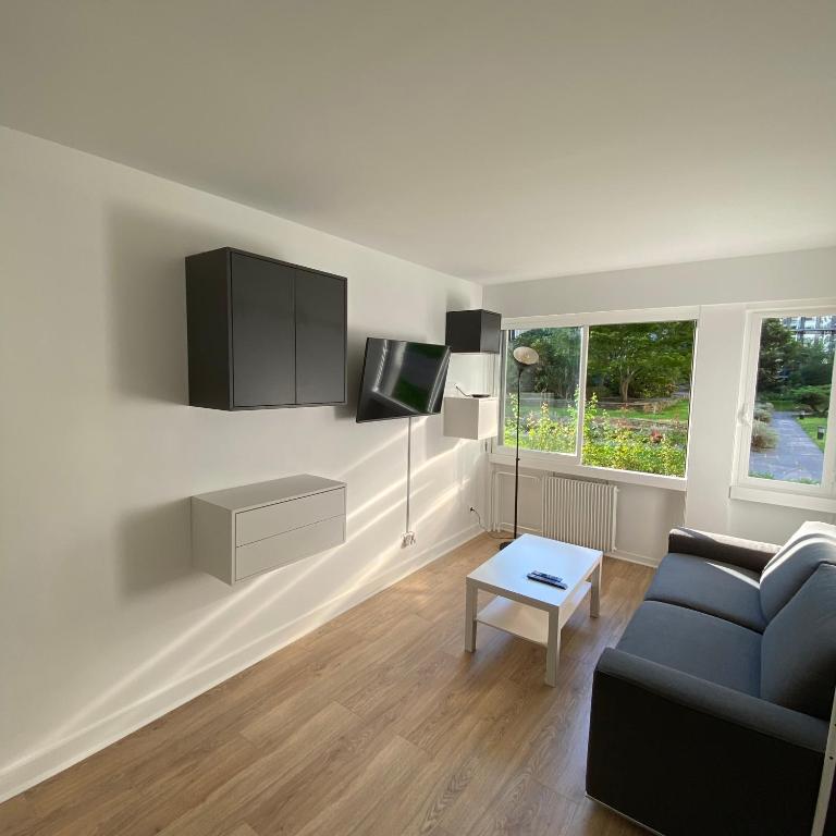 un salon avec un canapé et une télévision dans l'établissement Cocoon Meridien, à Paris