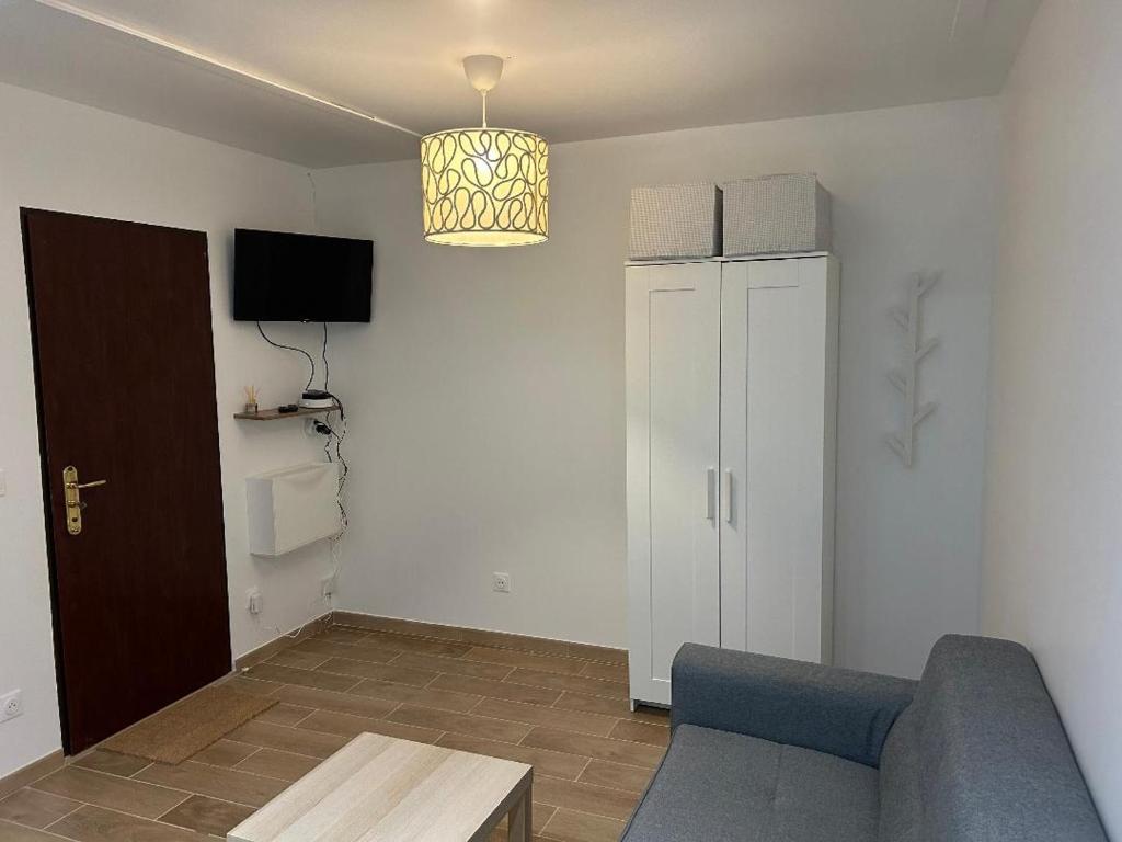 un salon avec un canapé bleu et une télévision dans l'établissement Tichy, à Paris