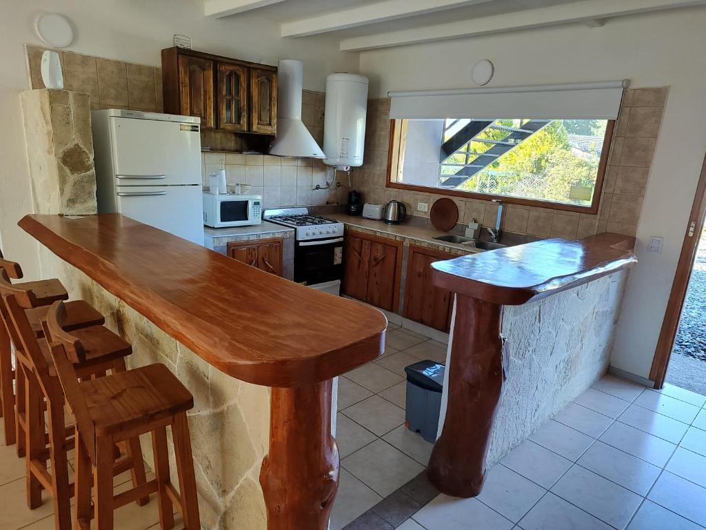 a kitchen with a wooden counter top in a room at Sol de montaña, Bariloche. in San Carlos de Bariloche
