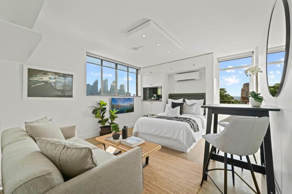 a bedroom and living room with a bed and a table at Modern Potts Point Studio in Sydney