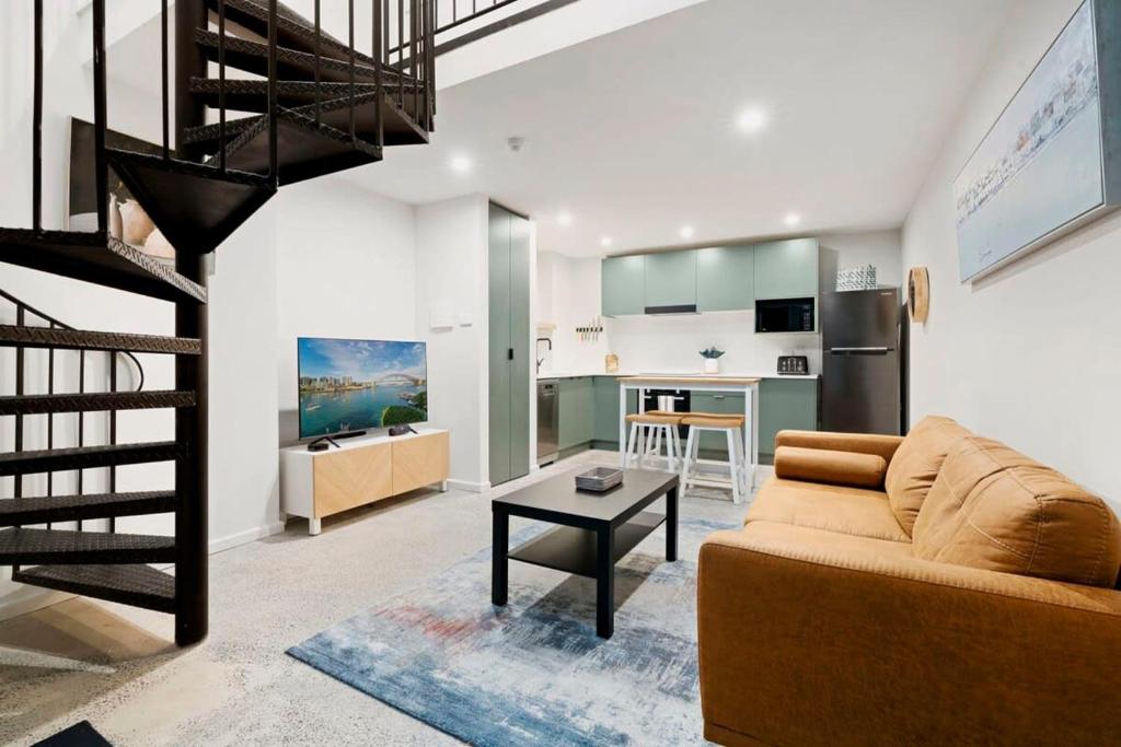 een woonkamer met een bank en een tafel bij Cosy Camperdown in Sydney