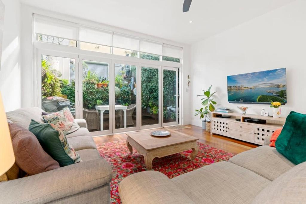 een woonkamer met 2 banken en een salontafel bij Bright Home in Trendy Newtown close to the Park in Sydney