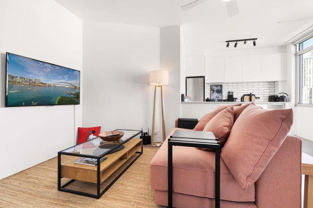雪梨的住宿－Best of city-suburbs living in trendy Darlinghurst，客厅配有粉红色的沙发和桌子