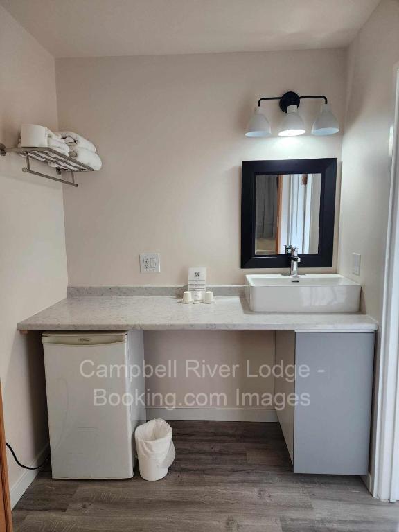 un bagno con lavandino e specchio di Campbell River Lodge a Campbell River