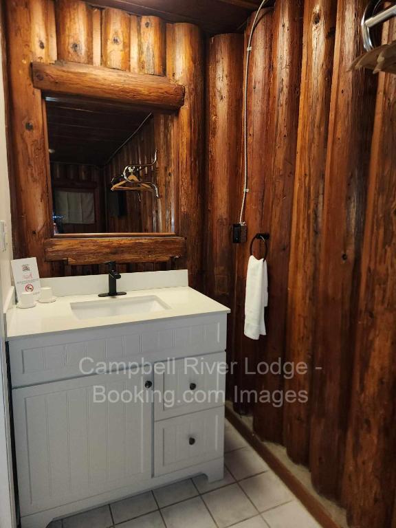 un bagno con lavandino e specchio di Campbell River Lodge a Campbell River
