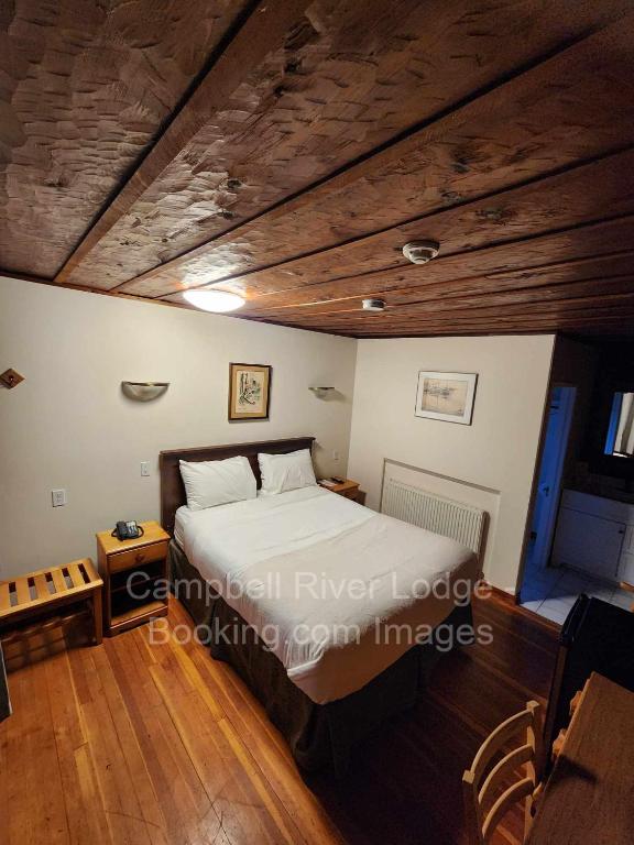 una camera con letto e soffitto in legno di Campbell River Lodge a Campbell River