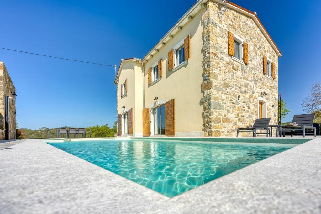 une villa avec une piscine en face d'un bâtiment dans l'établissement Villa Stara Hiza, à Novaki Pazinski