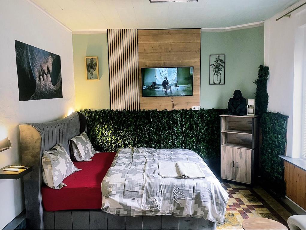 sypialnia z łóżkiem i telewizorem na ścianie w obiekcie Village Fertile w Charleroi